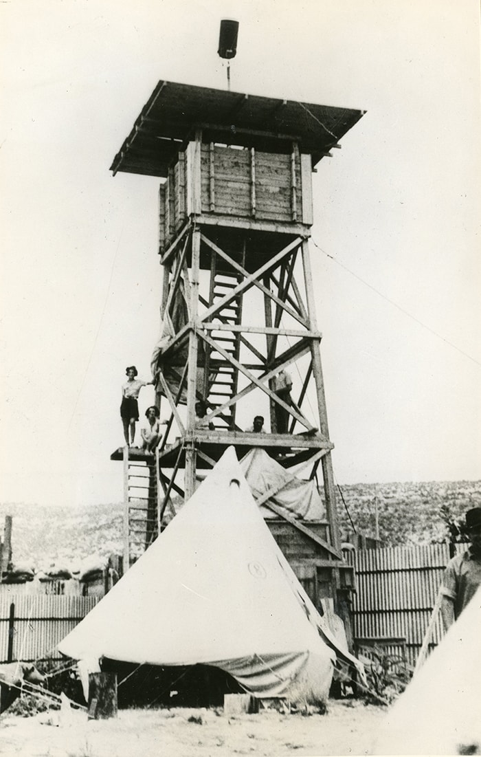 Stockade, tower, and tents at one of the settlements built in the Stockade and Tower operation